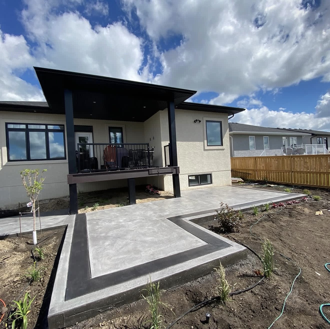 Smooth poured concrete patio with a dyed charcoal border band