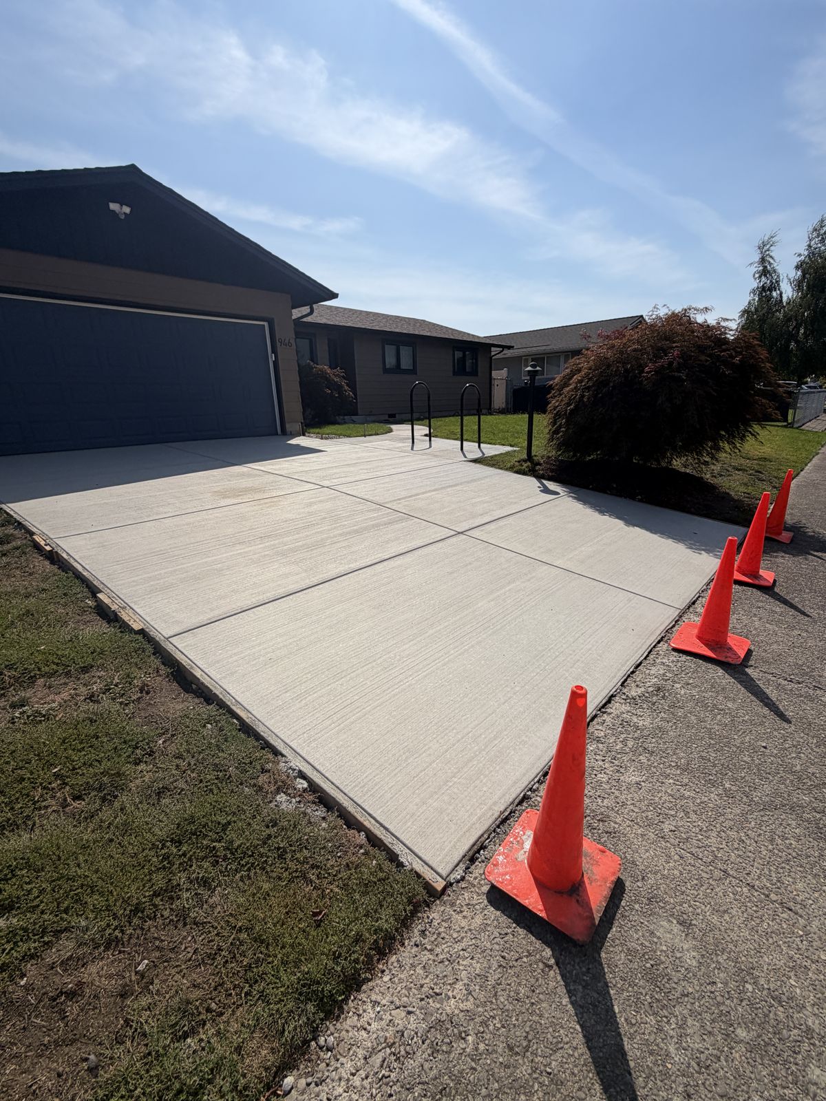 Freshly poured concrete driveway and front walkway with a broom finish and tooled edges